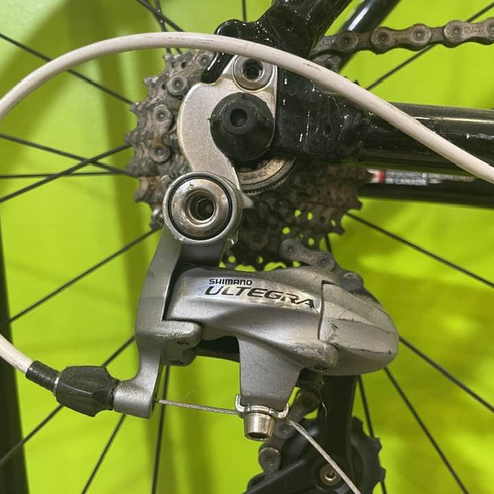 Bicycle derailleur with 'Shimano Ultegra' branding against a bright green background